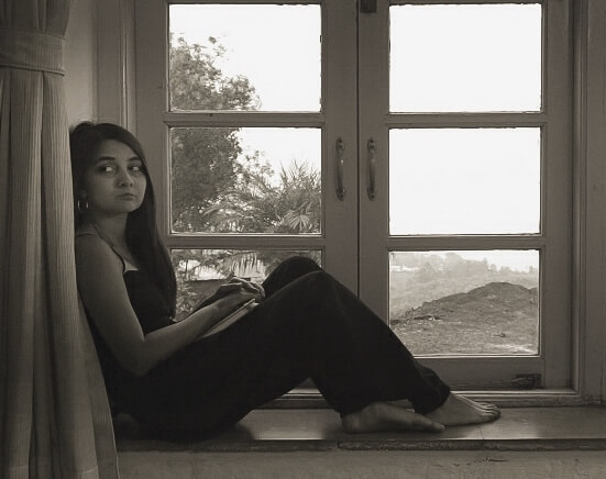 Rhea sitting on a windowsill thinking about Gratitude.